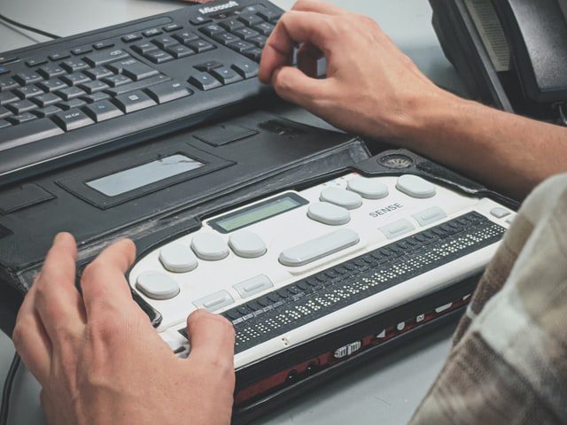 A blind man using a braille screen reader