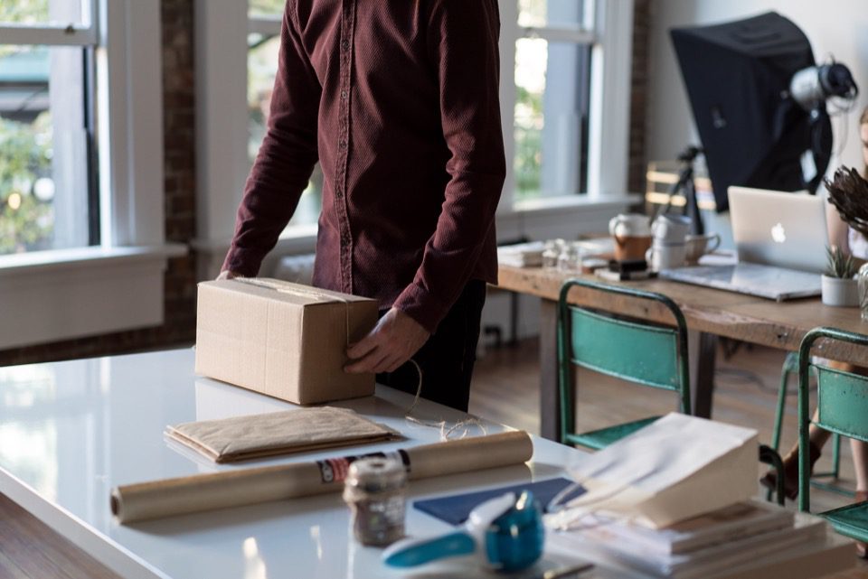 a person packing a product in a cardboard box