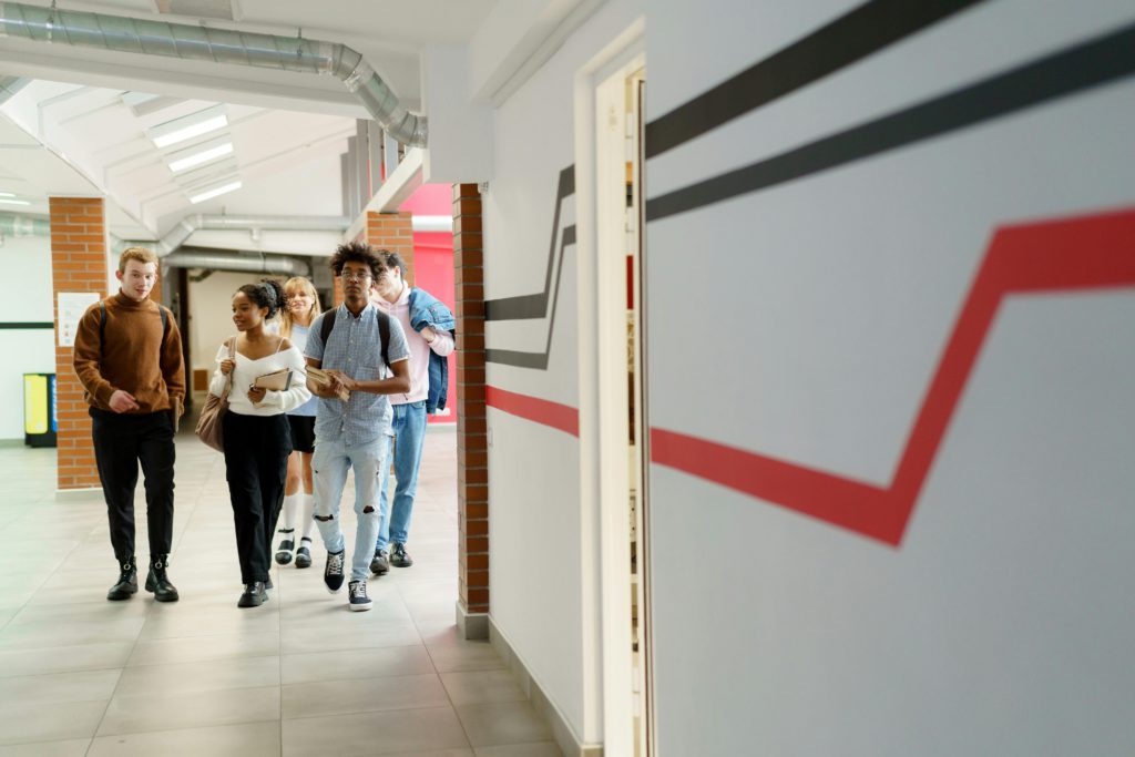 Five students walking through a hallway